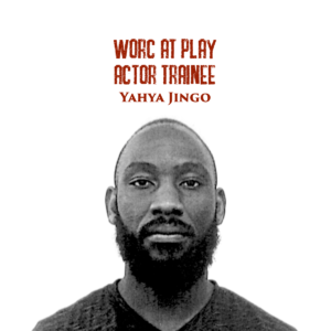 Black and white headshot of Yahya, a young black man with a mustache and beard looking straight into the camera. Red text on the top of the photograph reads "Worc At Play Actor Trainee Yahya Jingo".