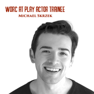 Black and white headshot of Michael, a young white man with short hair. He is smiling as he looks into the camera. Red text on the top of the photograph reads "Worc At Play Actor Trainee Michael Skrzek".