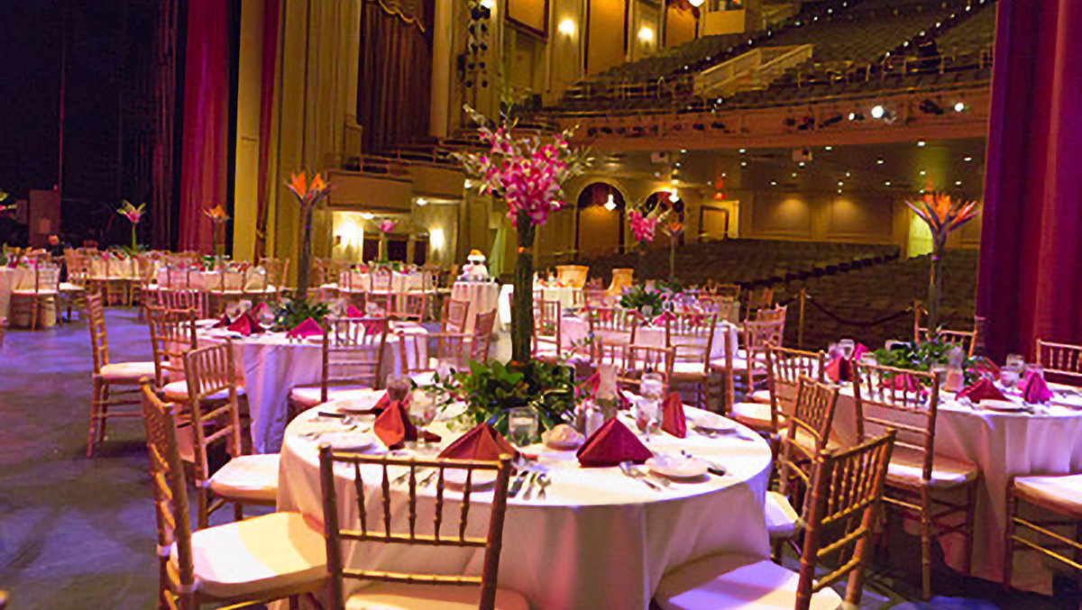 tables and chairs on stage in theater.