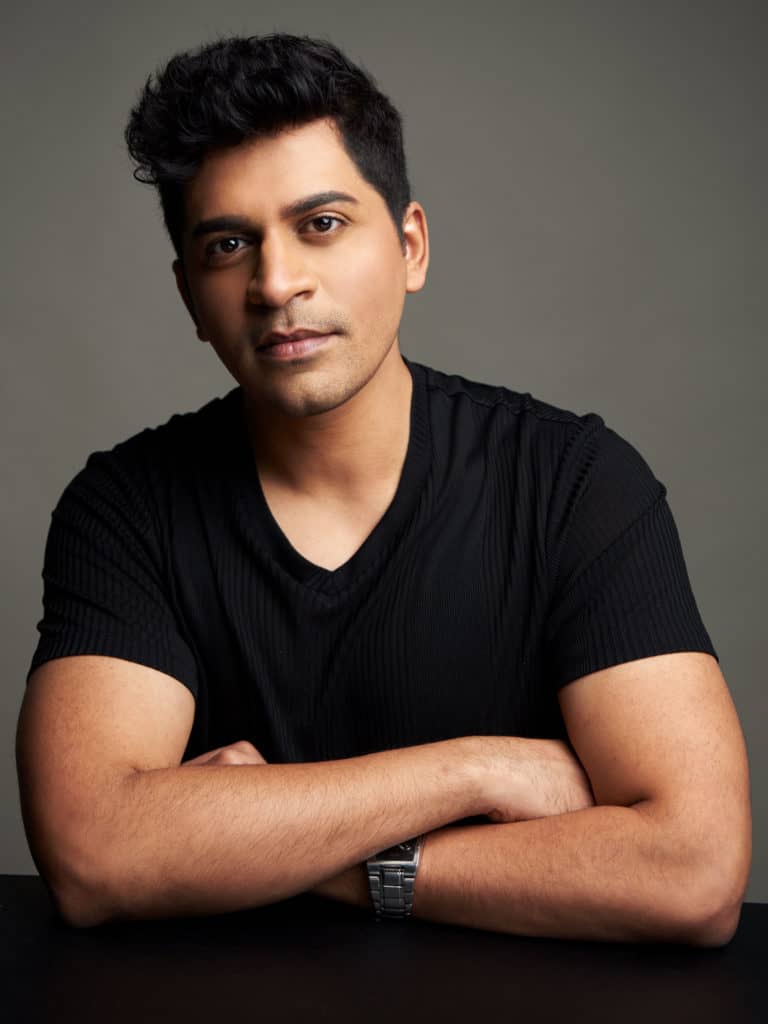 Sriram Emani poses for a headshot. He is looking into the camera and he is wearing a black t-shirt.