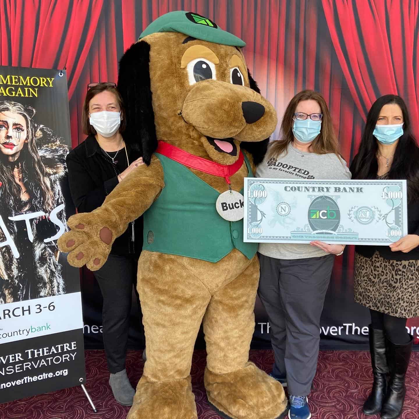 Lisa Condit, on the far left, stands next to a dog mascot. Kristin Mullins and Jodie Gerulaitis hold a giant $1,000 donation from Country Bank to Worcester Animal Rescue League.
