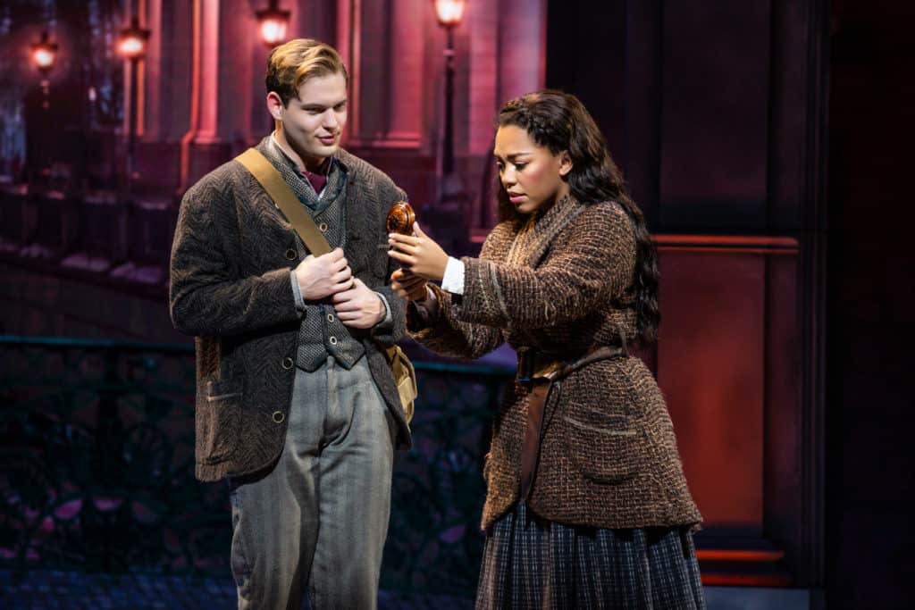 Anastasia (Kyla Stone) and Dmitry (Sam McLellan) are standing together, looking at a music box that Anastasia holds in her hands. 