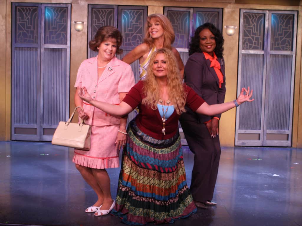 The four leads of Menopause the Musical are posing together, smiling as they look to the camera. 