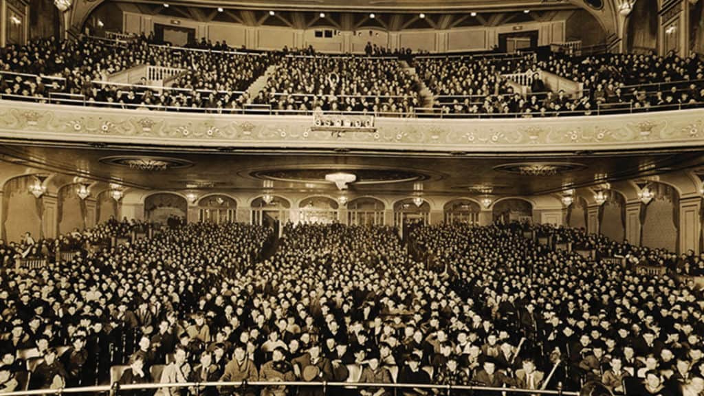 An antique, black and white photo of The Hanover Theatre's seats. The crowd is full of patrons both in the balcony and orchestra seating.