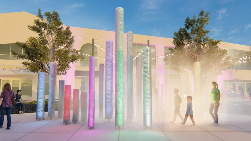 Concept art for the Francis R. Carroll plaza. Different metal columns are lit up different colors and spray mist. People walk alongside the columns. The Hanover Theatre is in the background.