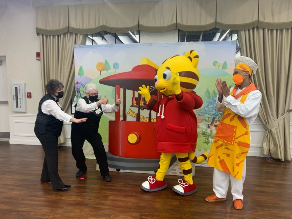 Two volunteers are standing with Daniel Tiger and The Baker from Daniel Tiger's Neighborhood Live.