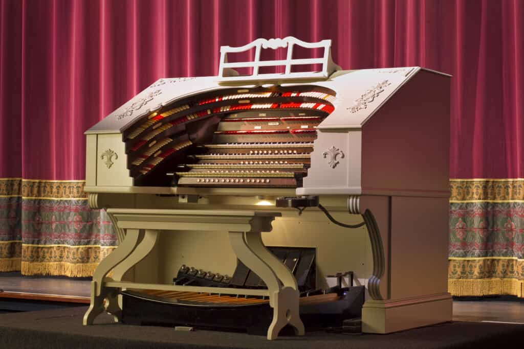 The Mighty Wurlitzer organ at The Hanover Theatre in front of the red curtain on stage.