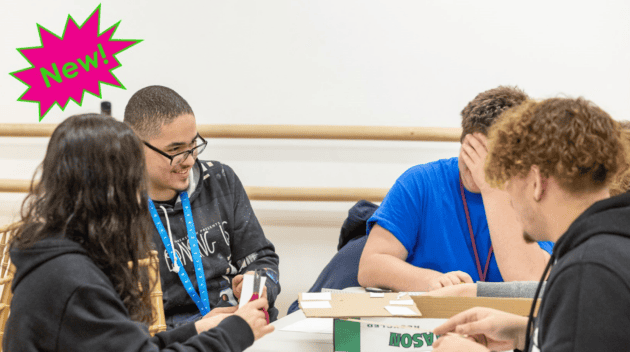 Four students converse with one another at their shared table in Extreme Weather workshop. In the upper left corner is a neon pink and green exclamation bubble with text inside: "New!"