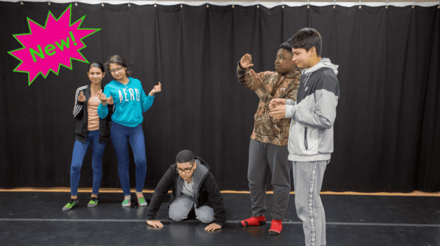 Promotional photo for EXPLORING STORY STRUCTURE THROUGH TABLEAU as five students are caught in various poses in front of a black curtain. In the upper left corner is a neon pink and green exclamation bubble with text inside: "New!"