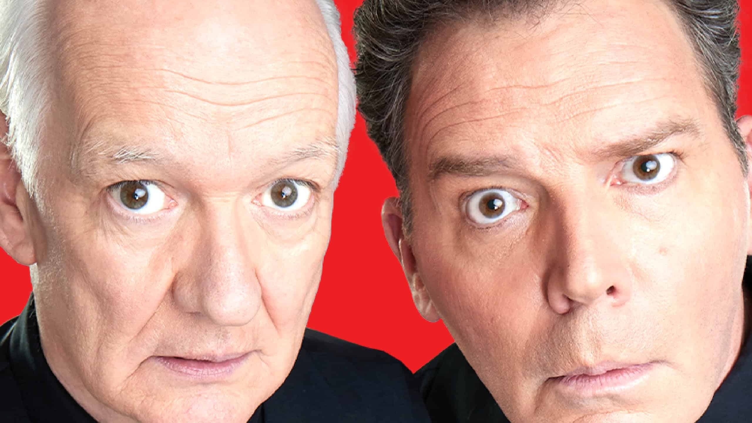 Close up photo of Colin Mochrie & Brad Sherwood looking surprised into the camera in front of a red background.