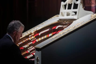 Dr. Jonathan Kleefield playing the red, yellow, and white keys of The Mighty Wurlitzer organ.