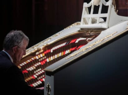 Dr. Jonathan Kleefield playing the red, yellow, and white keys of The Mighty Wurlitzer organ.
