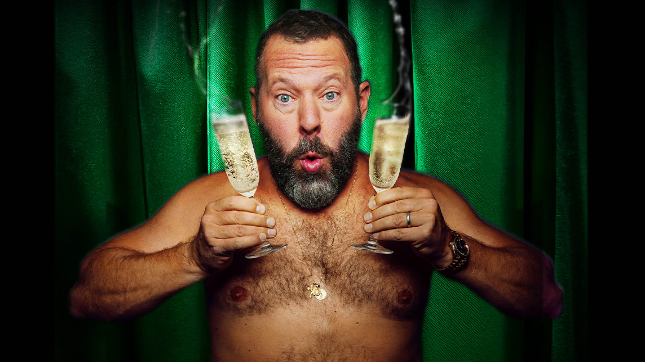 A shirtless man holds two overflowing glasses of champagne and looks excitedly at the camera