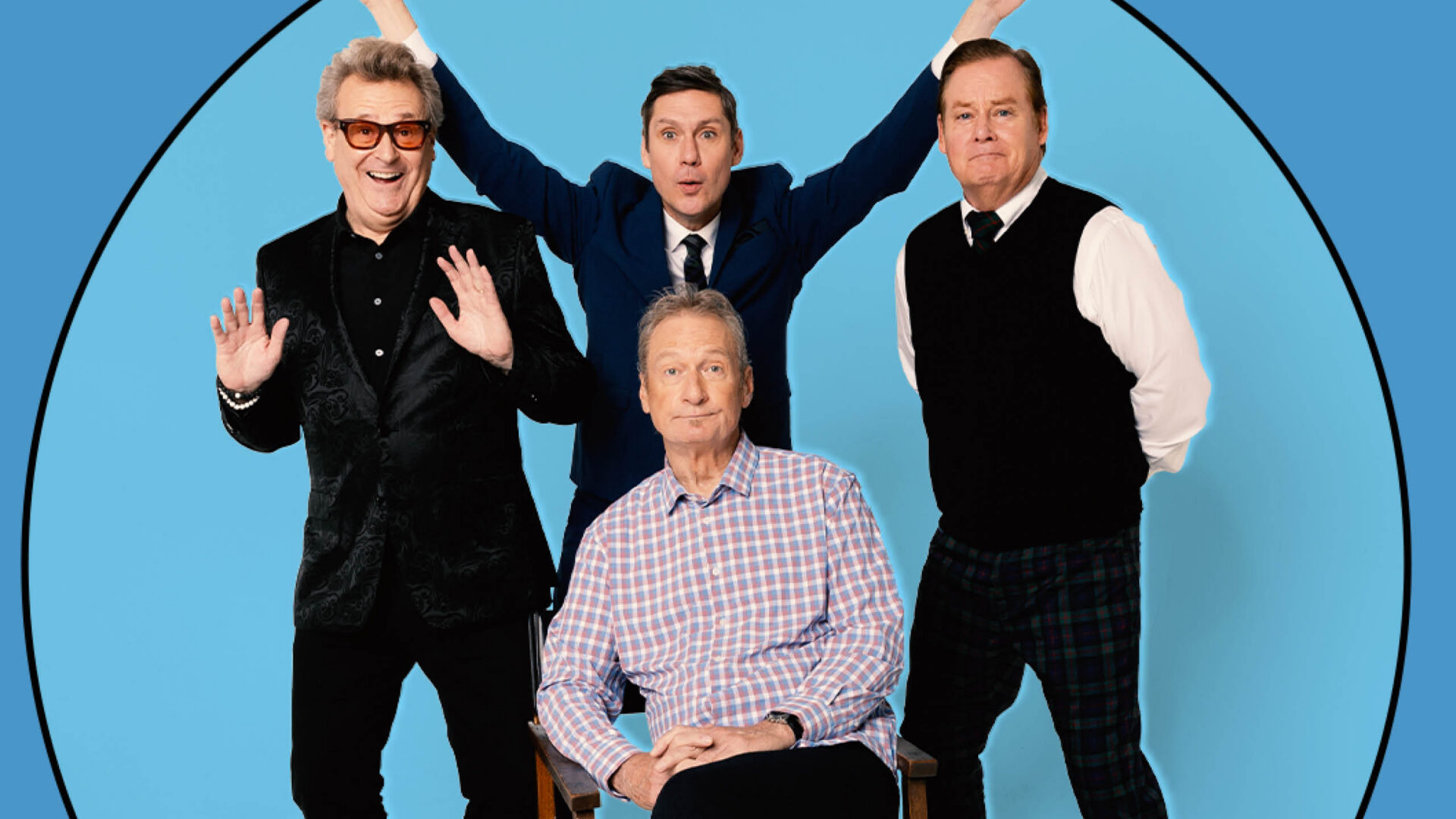 Four men posing together in a blue circular backdrop; one seated in a plaid shirt, the others standing with arms raised in celebration.