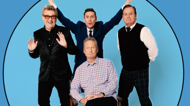 Four men posing together in a blue circular backdrop; one seated in a plaid shirt, the others standing with arms raised in celebration.